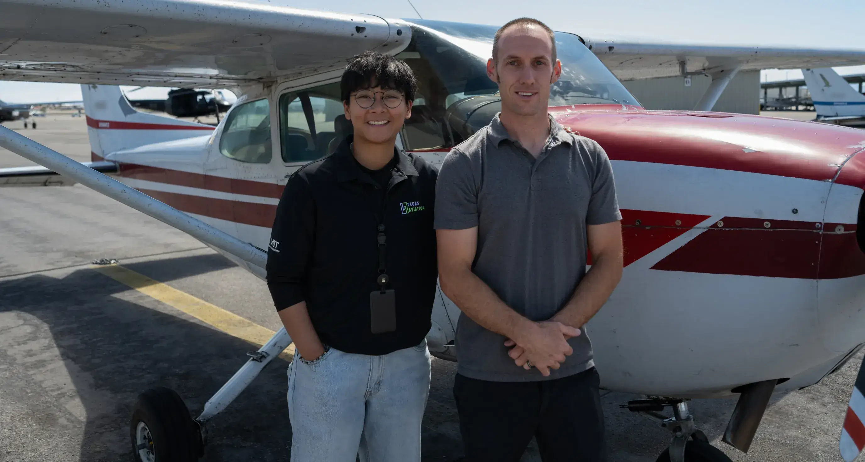 Student and certified flight instructor standing near a training aircraft