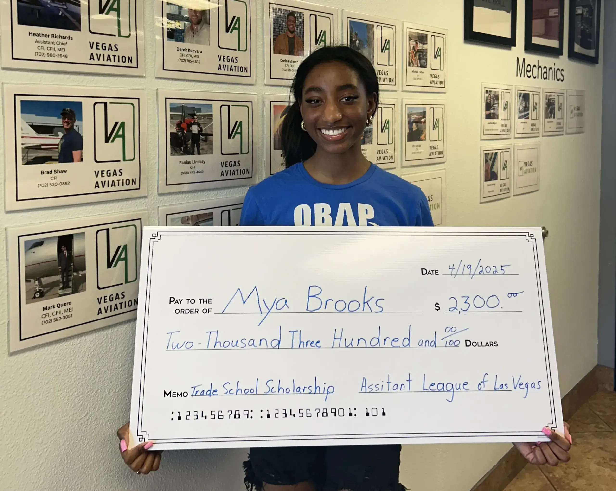 Mya Brooks holding a big check of two thousand and three hundred dollar scholarship